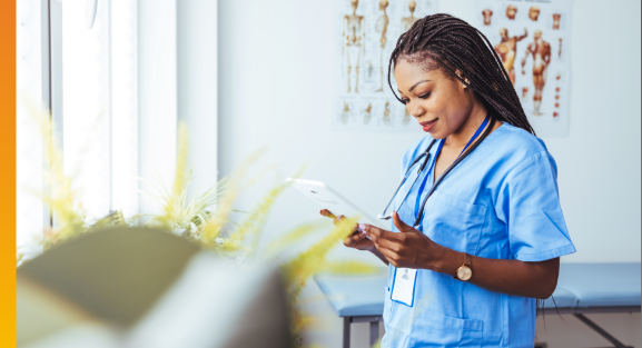 Healthcare professional reviewing information on a tablet in a clinical setting.