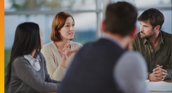 Business leaders in a meeting discussing strategy, governance and financial information.
