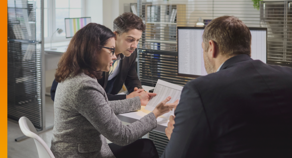 Business colleagues reviewing financial documents and data as part of a risk and controls discussion.